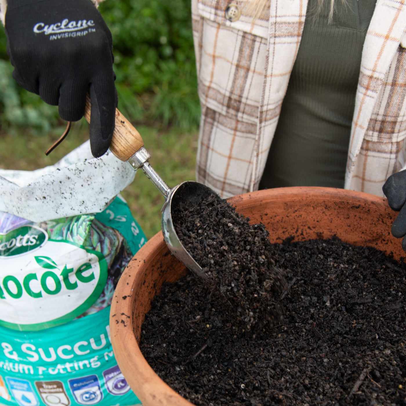 Lady with gardening gloves and a trowel using Cactus and Succulent potting mix